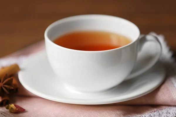 Чашка чая и специй на салфетке крупным планом — стоковое фото