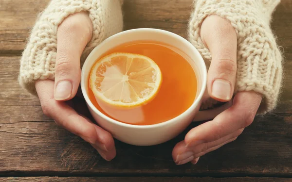 Female hands holding cup of tea — Stock Photo, Image