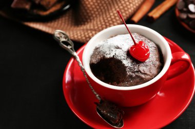 Çikolatalı kek ile bakir koyu bir arka plan üzerinde kırmızı bir kupa yakın çekim