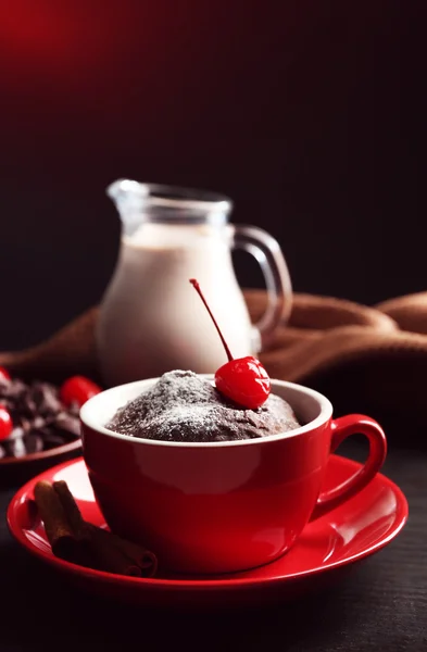 Çikolatalı kek kiraz siyah bir arka plan ile kırmızı bir kupa yakın çekim — Stok fotoğraf