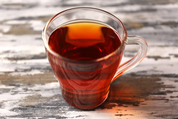 Coupe en verre de thé noir sur table en bois gros plan — Photo