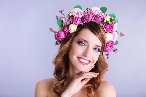 Mulher bonita vestindo headband floral em um fundo cinza — Fotografia de Stock