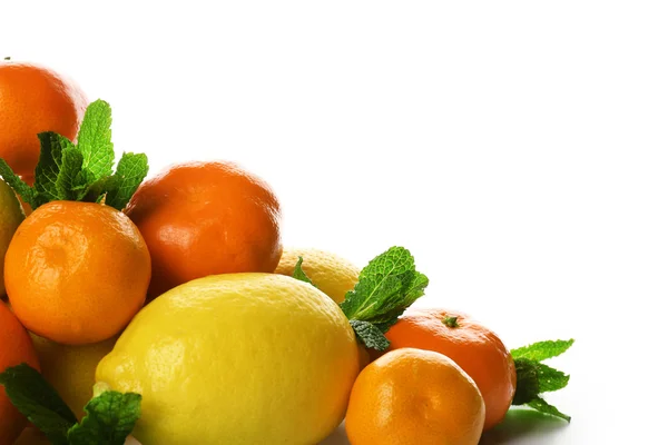 Un montón de cítricos mixtos incluyendo limones y mandarinas con ramitas de menta aisladas sobre un fondo blanco, de cerca — Foto de Stock