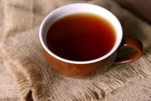 Taza de té en tela de saco primer plano — Foto de Stock