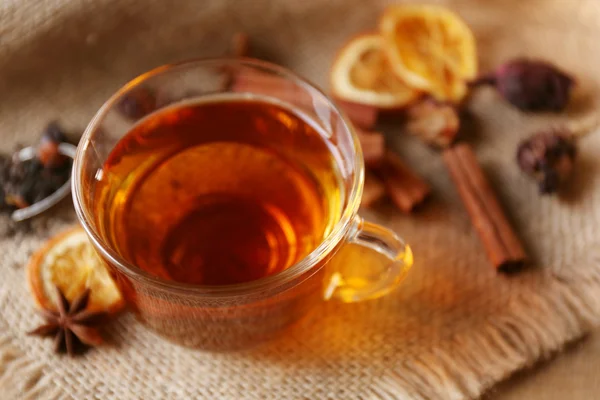 Glas kopp te med kryddor på säckväv närbild — Stockfoto
