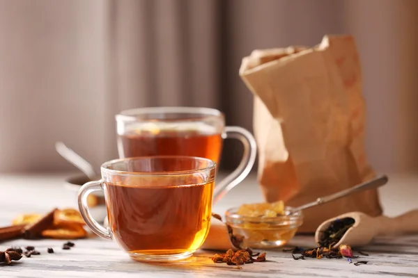 Glass cup of tea with spices on blurred background — Stock Photo, Image