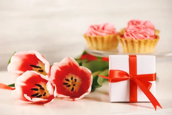 Huidige doos met tulpen en cupcakes — Stockfoto