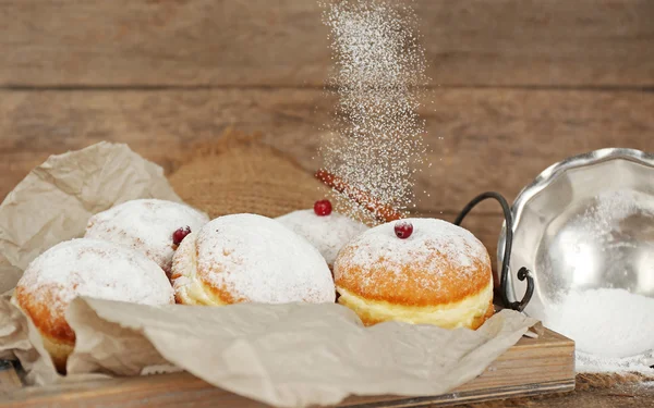 Deliciosas rosquillas azucaradas con grosella roja sobre fondo de madera — Foto de Stock