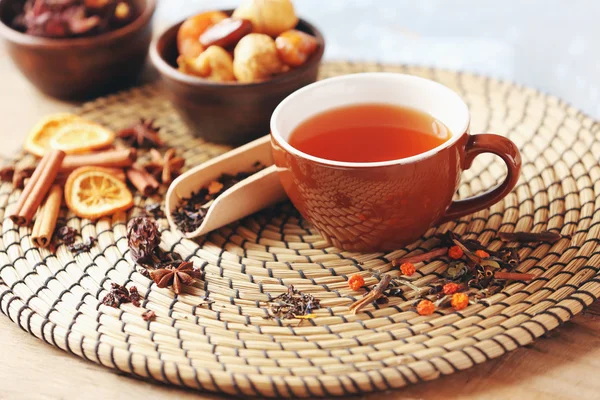 Tasse Tee und getrocknete Früchte auf Weidenschale Nahaufnahme — Stockfoto