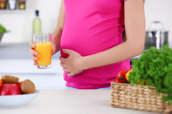 Mujer embarazada con vaso de jugo de naranja — Foto de Stock