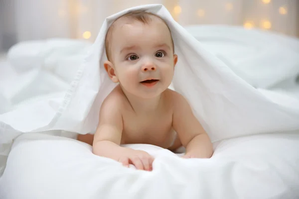 Bebê adorável em cama macia — Fotografia de Stock