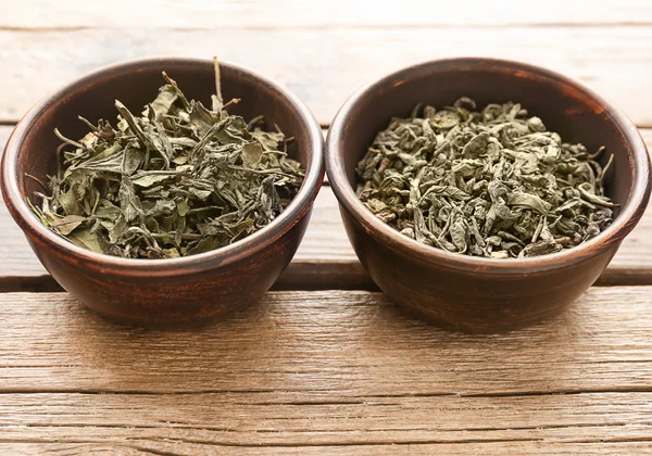 Twee soorten thee in een ronde kommen op houten tafel, close-up — Stockfoto