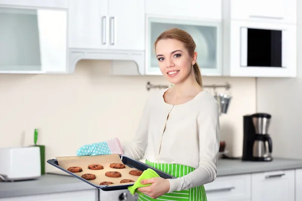 Mujer joven sosteniendo una bandeja de galletas — Foto de Stock