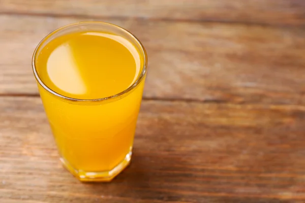 Vaso de zumo de naranja sobre fondo de madera, primer plano —  Fotos de Stock