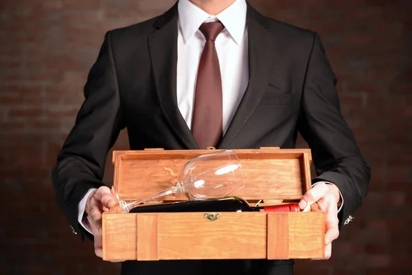 Hombre sosteniendo una botella de vino tinto y vidrio — Foto de Stock