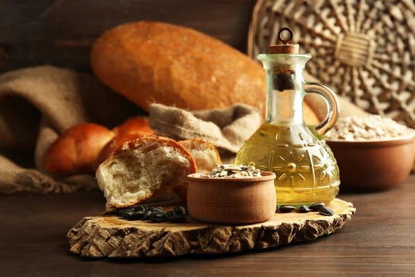 Ayçiçeği tohumu, ekmek ve yağ ahşap masa arka planda, closeup bileşimi — Stok fotoğraf