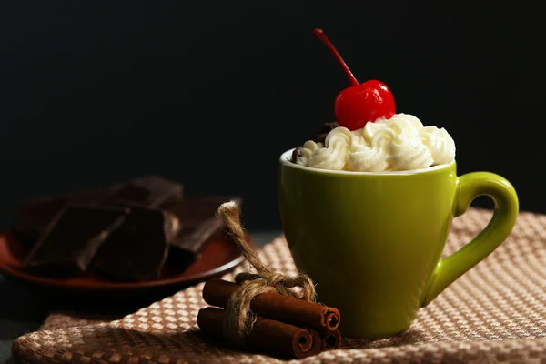 Pastel de chocolate en una taza verde con crema batida y una cereza en la parte superior, de cerca —  Fotos de Stock