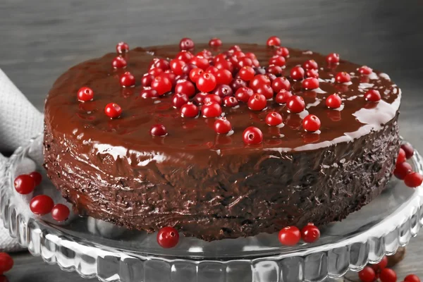 Bolo de chocolate com cranberries em fundo de madeira, close-up — Fotografia de Stock