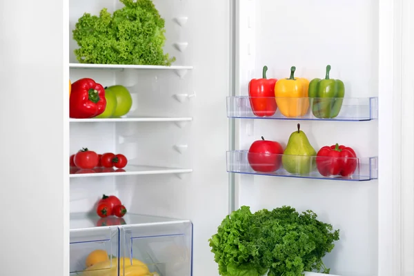 Frigorífico aberto com frutas e legumes frescos na cozinha — Fotografia de Stock