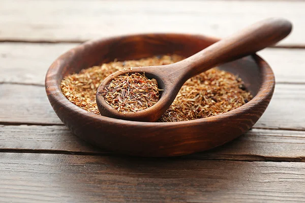 Rooibos thé dans un bol rond sur une table en bois, fermer — Photo