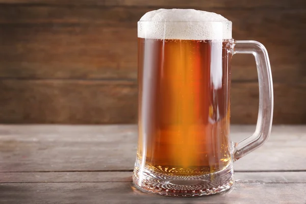 Glaskrug mit hellem Bier auf Holztisch, Nahaufnahme — Stockfoto