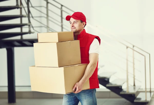 Hombre sosteniendo pila de cajas de cartón — Foto de Stock