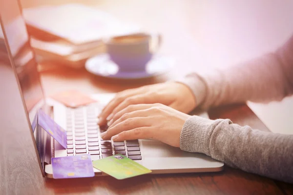 Concetto di commercio elettronico. Donna con carta di credito, laptop e tazza di caffè, primo piano — Foto Stock