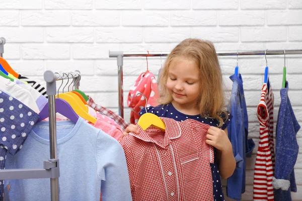 Liten flicka försöker på klänning — Stockfoto