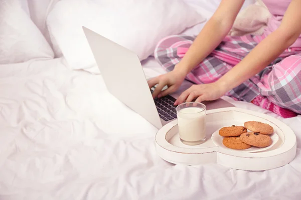 Mujer usando un ordenador portátil en la cama — Foto de Stock