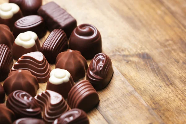 Delicious chocolate candies on wooden background — Stock Photo, Image