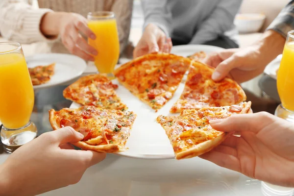 Freunde halten heiße Pizza in den Händen — Stockfoto