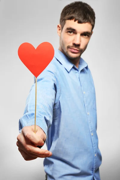 Hombre sosteniendo corazón de papel rojo — Foto de Stock