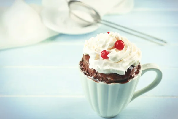 Bolo de caneca com creme e cranberry no fundo de madeira azul — Fotografia de Stock