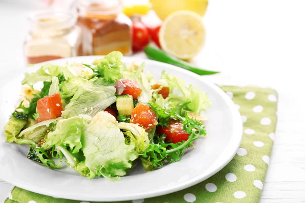 Tasty salmon salad on light wooden background — Stock Photo, Image