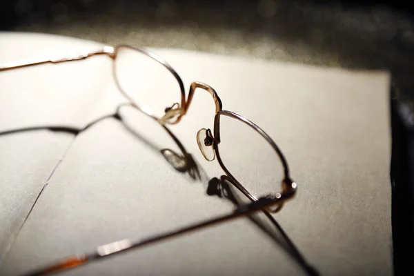 Opened book and eyeglasses — Stock Photo, Image