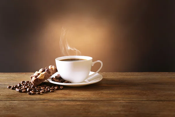 Tasse Kaffee auf Tisch auf braunem Hintergrund — Stockfoto