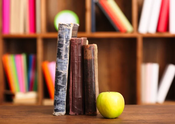 Libros y manzana sobre la mesa — Foto de Stock