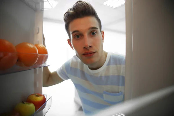 Uomo in cerca di cibo in frigorifero — Foto Stock