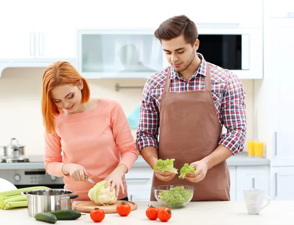 Casal cozinhar salada na cozinha — Fotografia de Stock