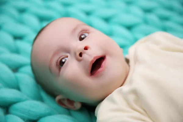 Underbar bebis på stickade turkos bakgrund — Stockfoto