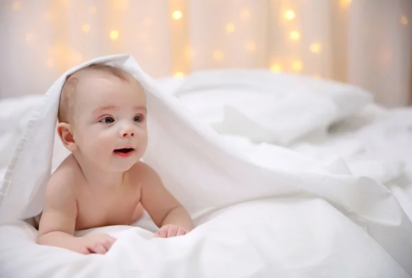 Bebê adorável em cama macia — Fotografia de Stock