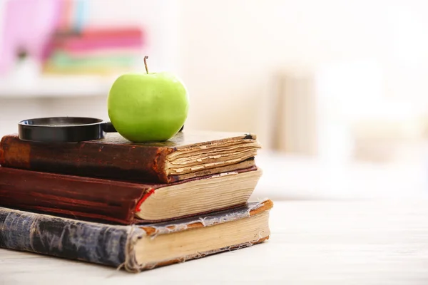 Libros y manzana sobre la mesa — Foto de Stock