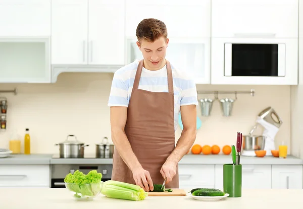 Uomo cucina in cucina luminosa — Foto Stock