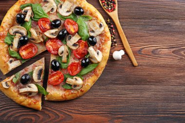 Sebze ile lezzetli lezzetli pizza ahşap masanın üzerine dilimlenmiş