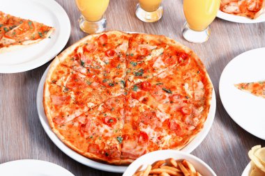 Evde pizza ve içecekler için arkadaşları ile tablo