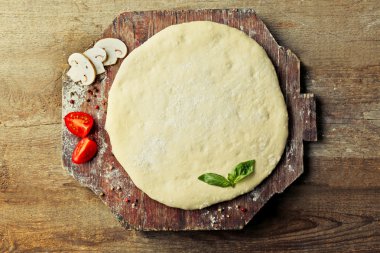 Taze hamur pizza domates ve ahşap bir gemide dilimlenmiş mantar ile hazırlanan yakın çekim