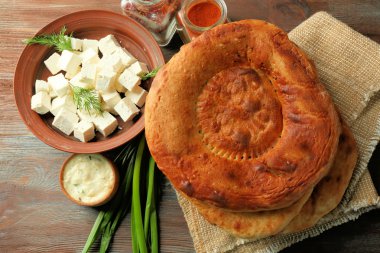 Taze kızarmış ekmek peynir, uçan daire ve ahşap masa portre üzerinde taze soğan ile