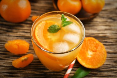 Mandalina kokteyl ile dilimlenmiş mandalina, buz, nane bir çizgili yüzeye yakın