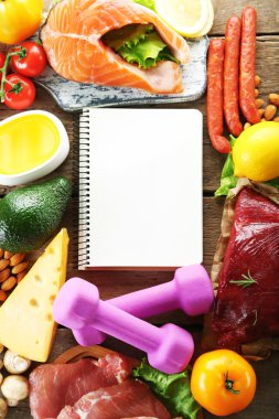 Diyet yiyecek ve ahşap arka plan üstünde defter