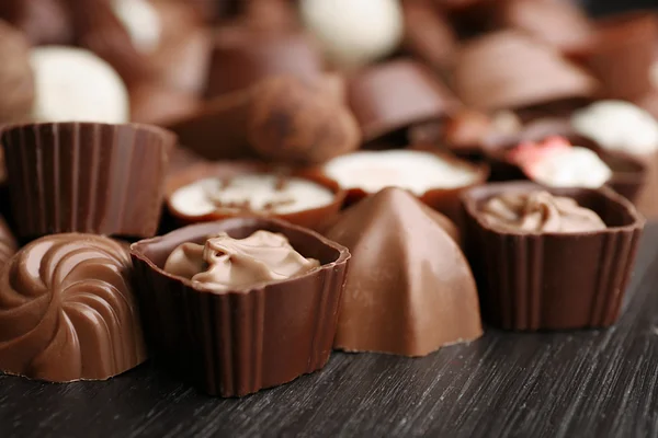 Heerlijke chocolade snoepjes op houten achtergrond, close-up — Stockfoto